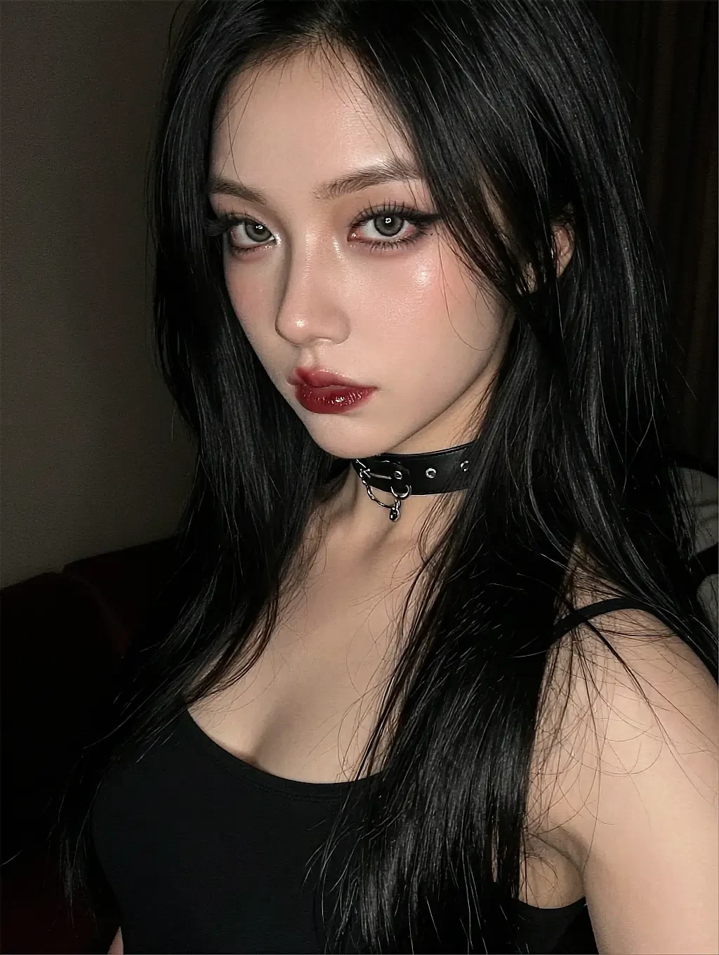 Fictional AI character with dark hair and a choker, bare-shouldered in near-darkness